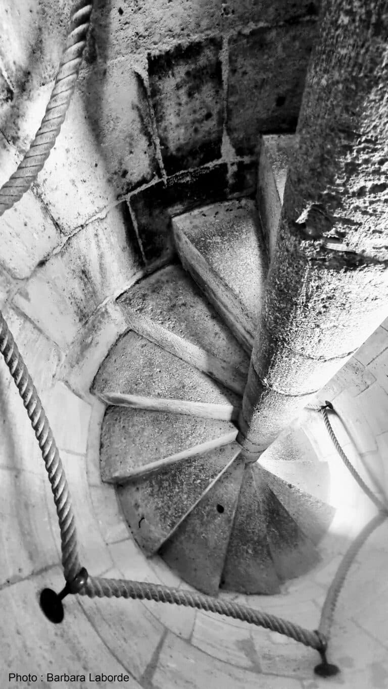 Vue plongeante sur l'escalier en pierre du phare de Richard, avec sa rampe de corde qui accompagne l'ascension vers le sommet de la tour.